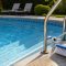 Clear swimming pool with ladder, steps, and pool brush for cleaning hidden algae spots