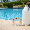 Pool water testing kit beside a clean backyard swimming pool