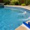 Clear swimming pool with return jet circulation and maintenance tools on deck