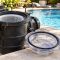 Pool pump lid O-ring, clear pump lid, strainer basket, and silicone lubricant arranged beside a clean residential pool.