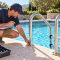 Pool professional inspecting a stainless pool ladder and handrail before swim season